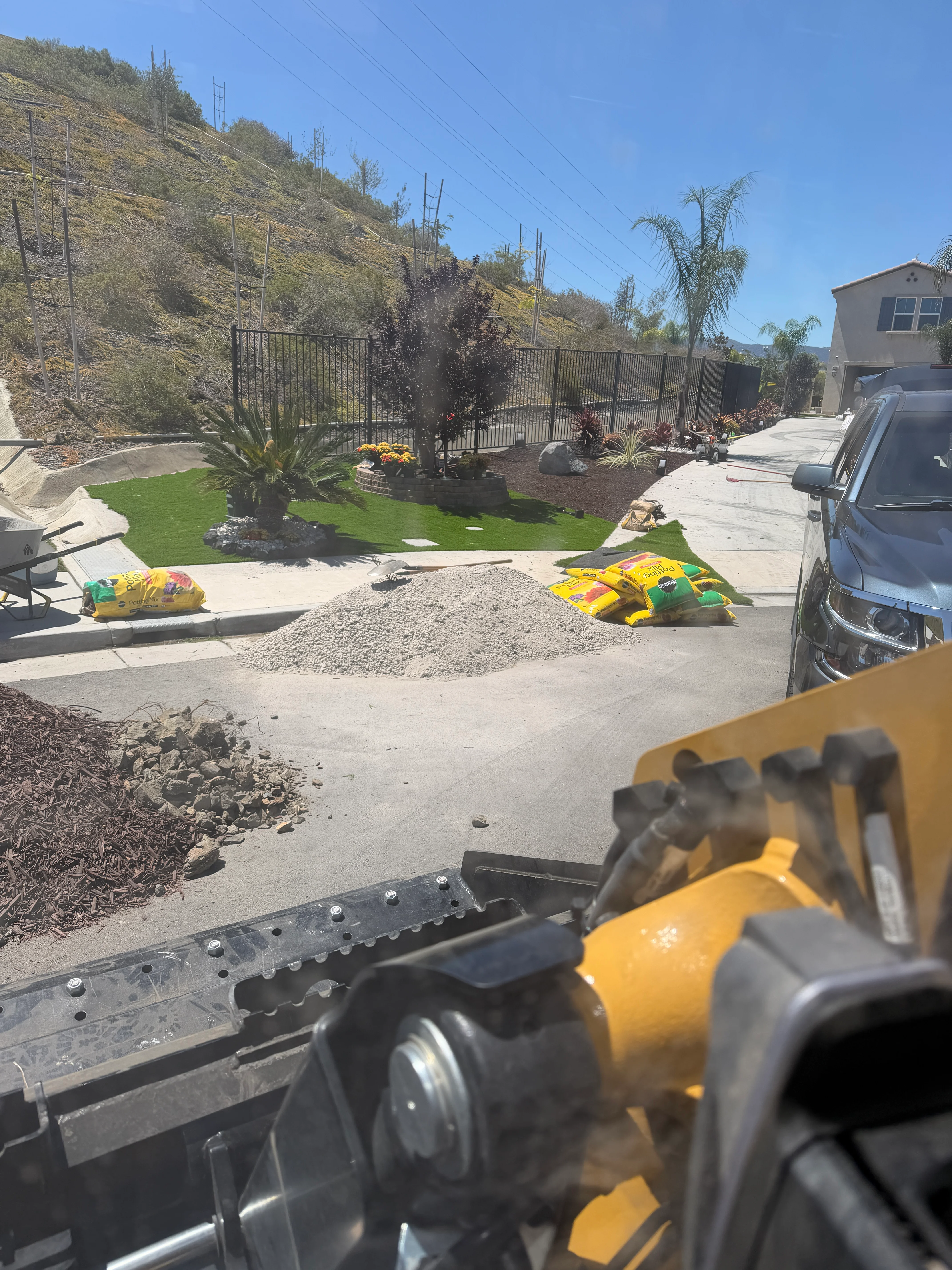 Excavated hillside lot with fresh grading, black fence, and new landscaping in Canyon Lake