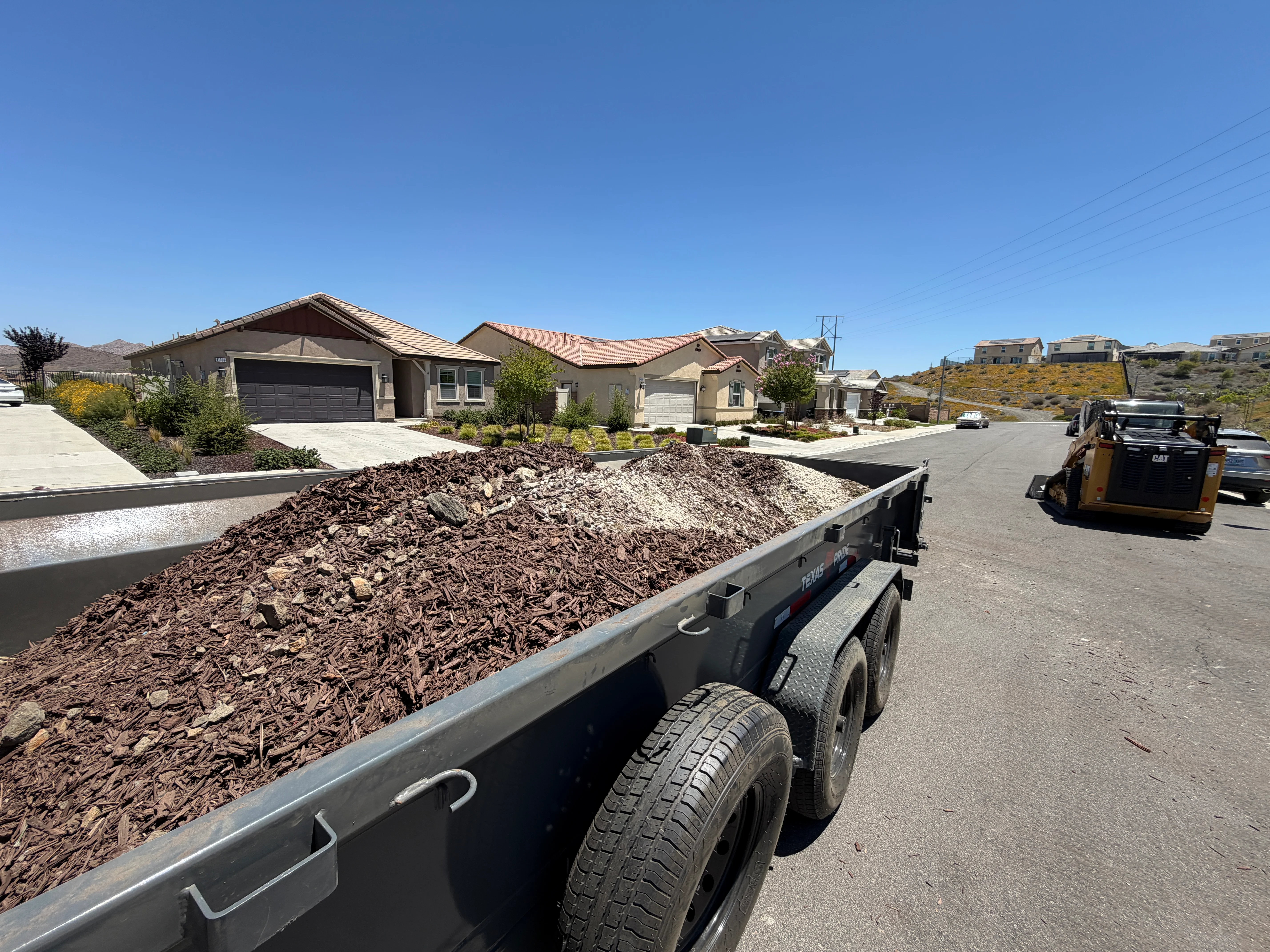 Dump truck loaded with wood chip mulch at cleared residential lot in Canyon Lake