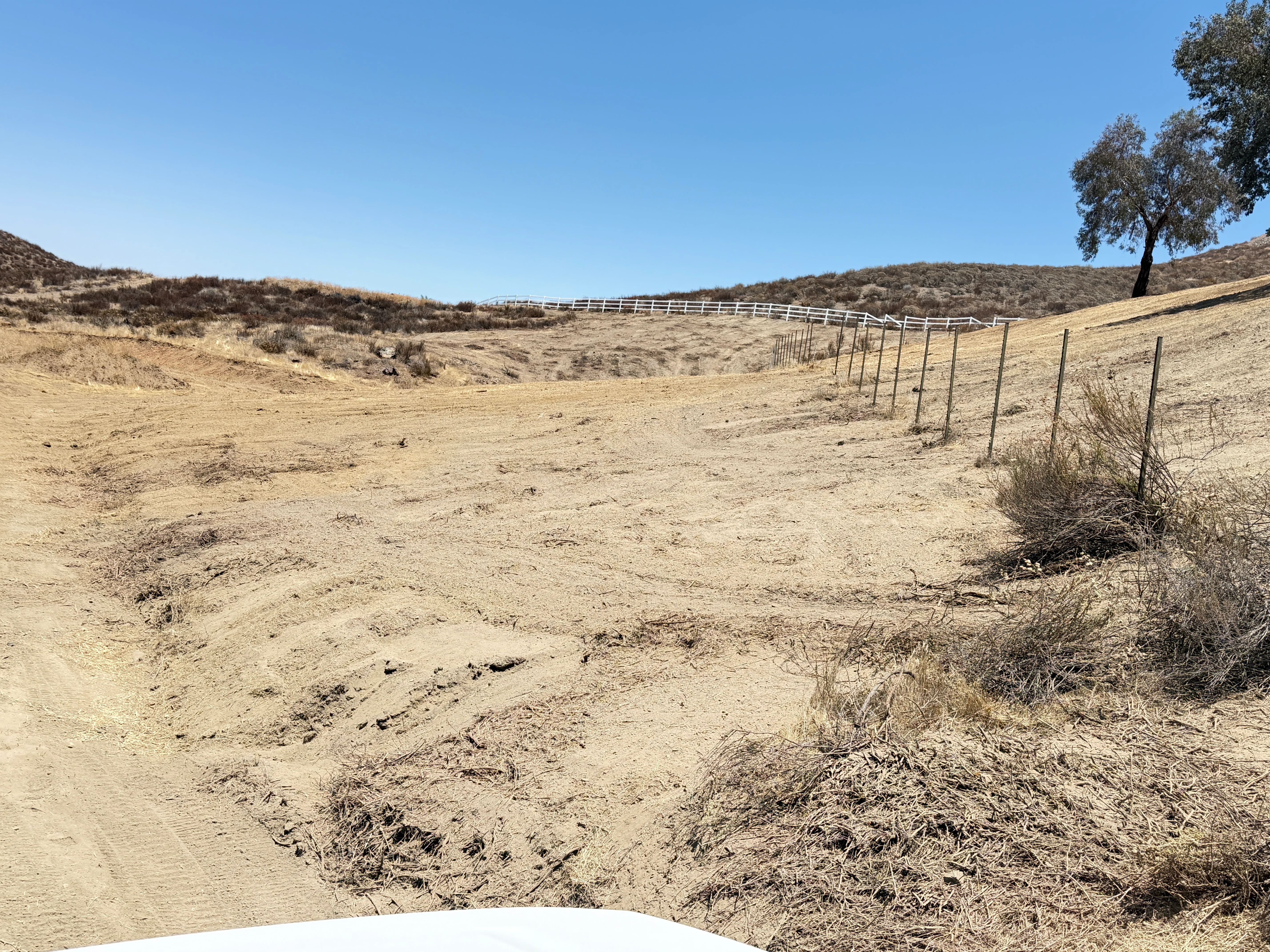 Cleared hillside property with metal fencing and graded dirt terrain in Canyon Lake